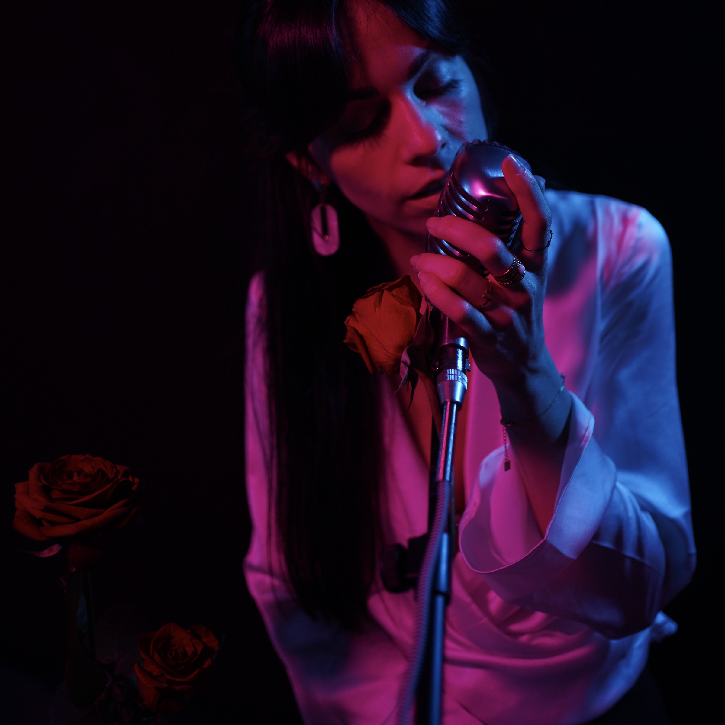 Marey chante au micro dans une lumière rouge et bleue