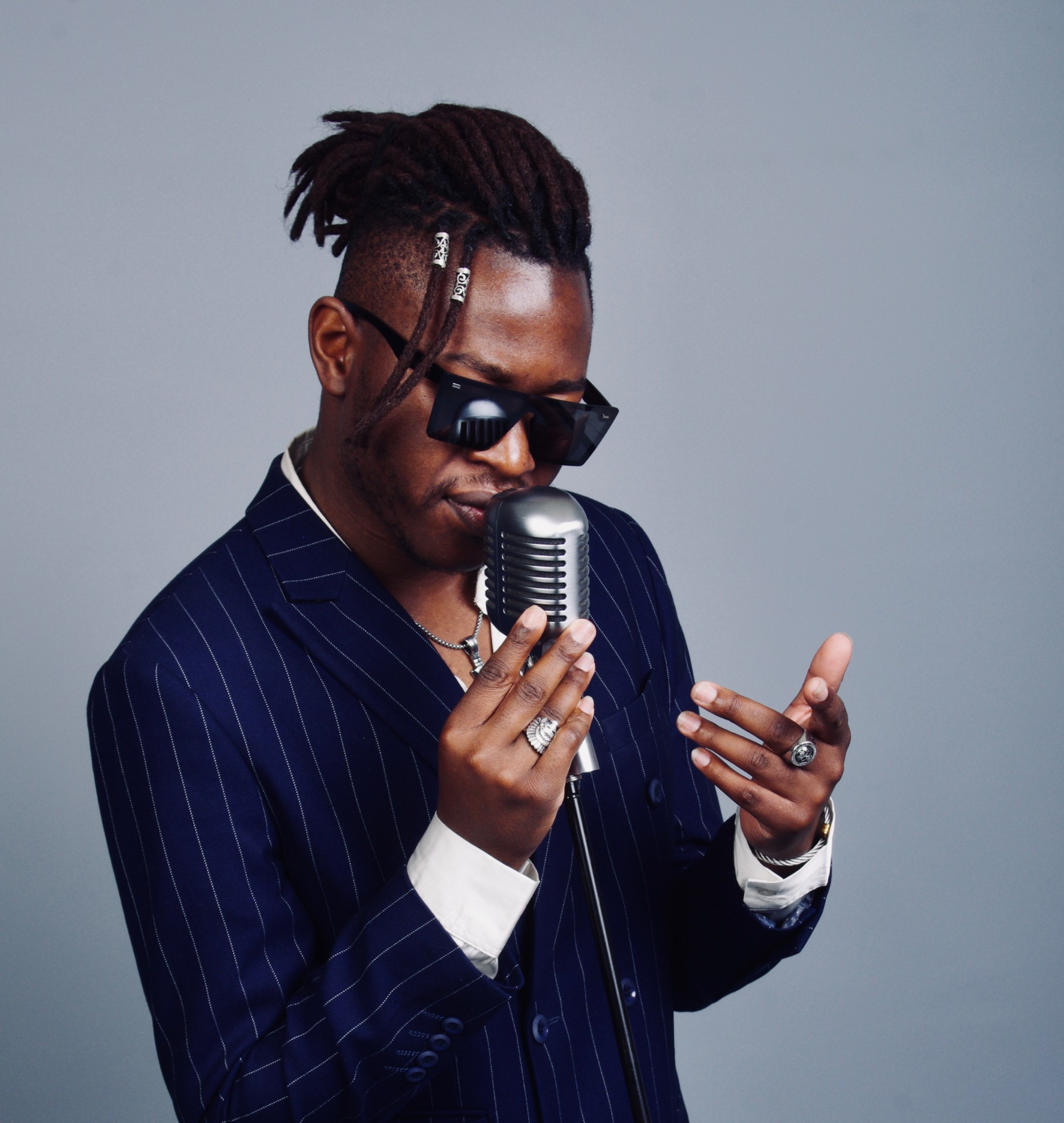 Eric Maseko au chant en costume rayé